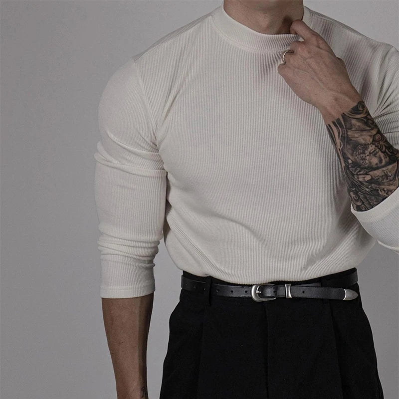 Tenue casual chic avec le pull EZEKIEL blanc, associé à un pantalon noir pour un style épuré et moderne.