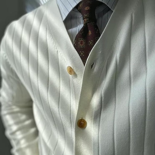 Zoom sur le col V du cardigan blanc ARCHIBALD, une coupe classique et intemporelle qui ajoute une touche de sophistication à cette pièce raffinée