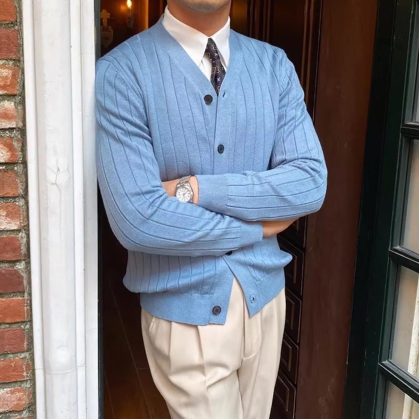 Cardigan bleu clair ARCHIBALD en laine douce, avec un col V raffiné et un boutonnage discret, pour une allure élégante et intemporelle.