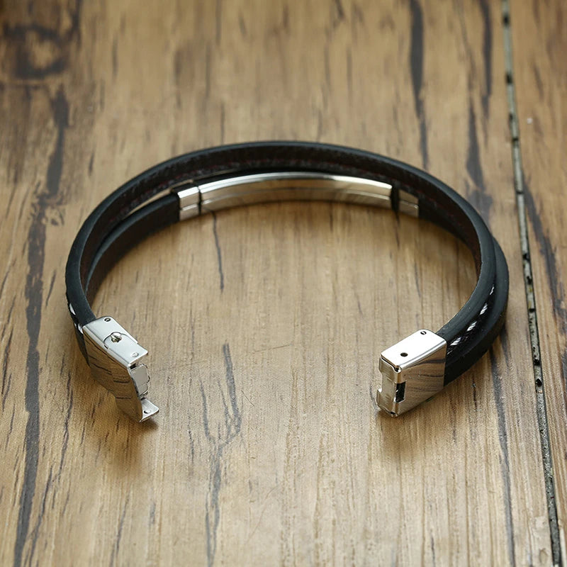 Zoom sur le fermoir du bracelet en cuir tressé noir avec plaque en acier inoxydable