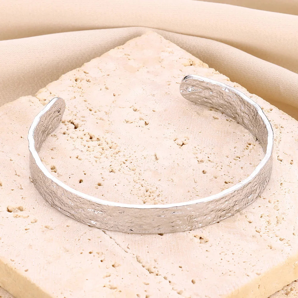 Bracelet fin manchette argenté pour femme, design irrégulier et finition brillante en acier inoxydable.