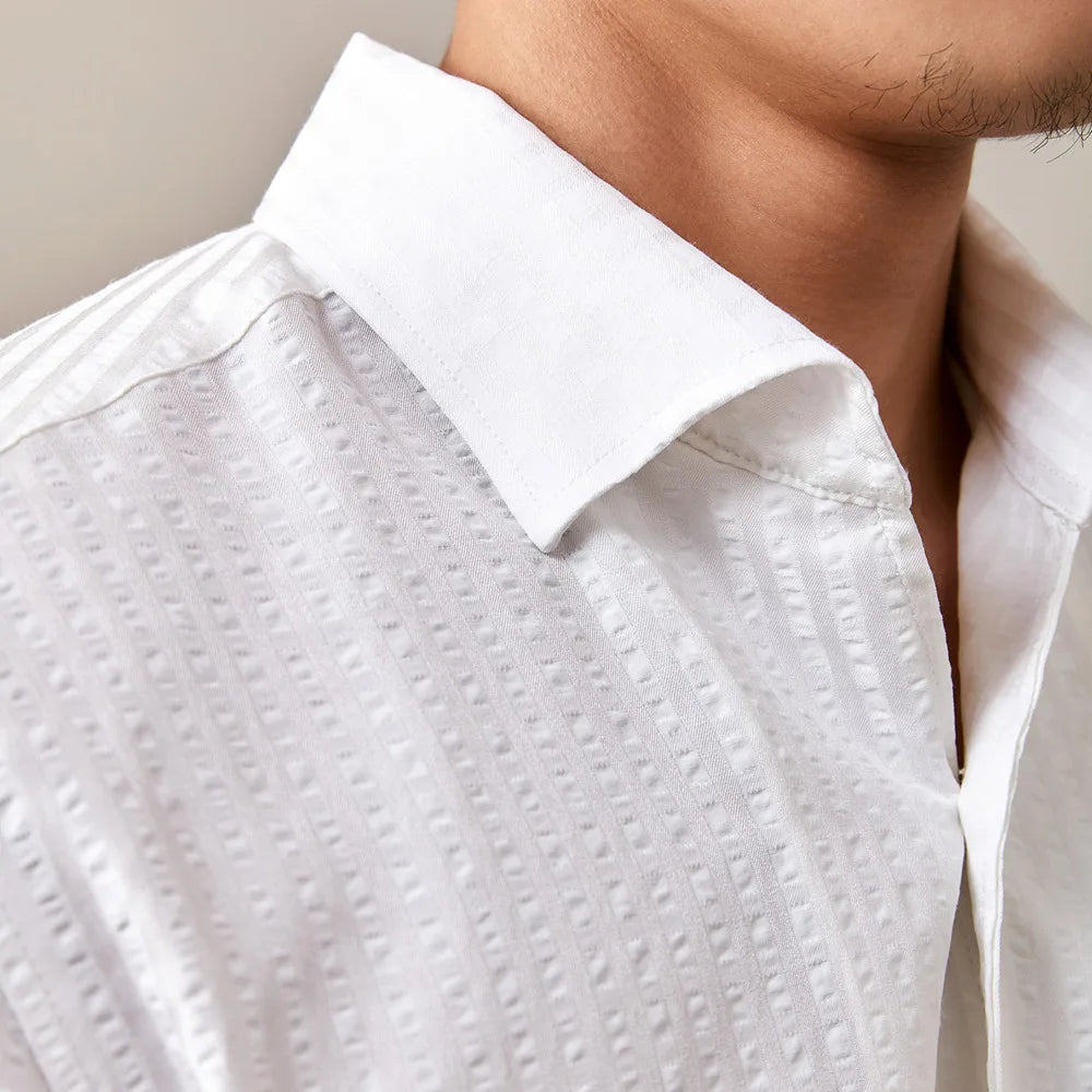 Gros plan sur le tissu en coton blanc de la chemise, mettant en évidence sa douceur et sa légèreté, pour une sensation de confort durable.