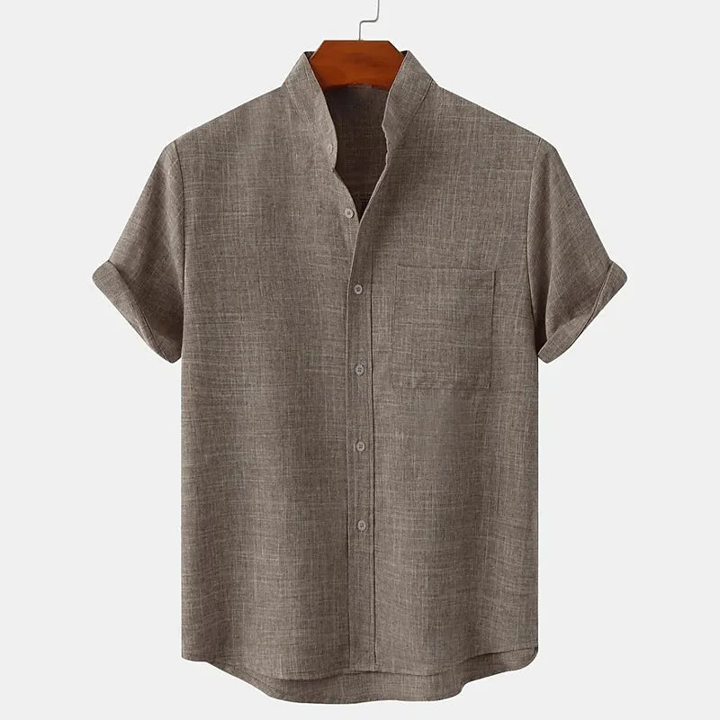 Vue de face de la chemise à manches courtes en chanvre gris clair, avec une texture naturelle et aérée qui assure un confort optimal. Le tissu en chanvre est léger, durable et respirant, tandis que la coupe décontractée et fluide offre une silhouette élégante. Zoom sur les détails du col structuré et du boutonnage minimaliste.