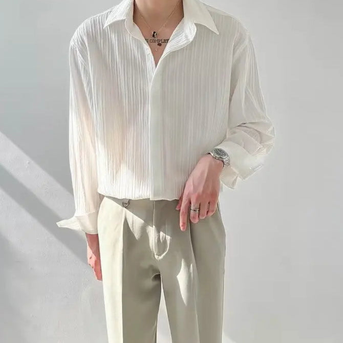 Détail du tissu plissé de la chemise blanche pour homme, texture raffinée et effet fluide pour une allure sophistiquée