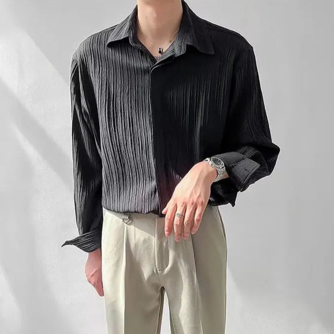 Homme portant la chemise plissée noire, tombé parfait et matière plissée de qualité pour un look habillé