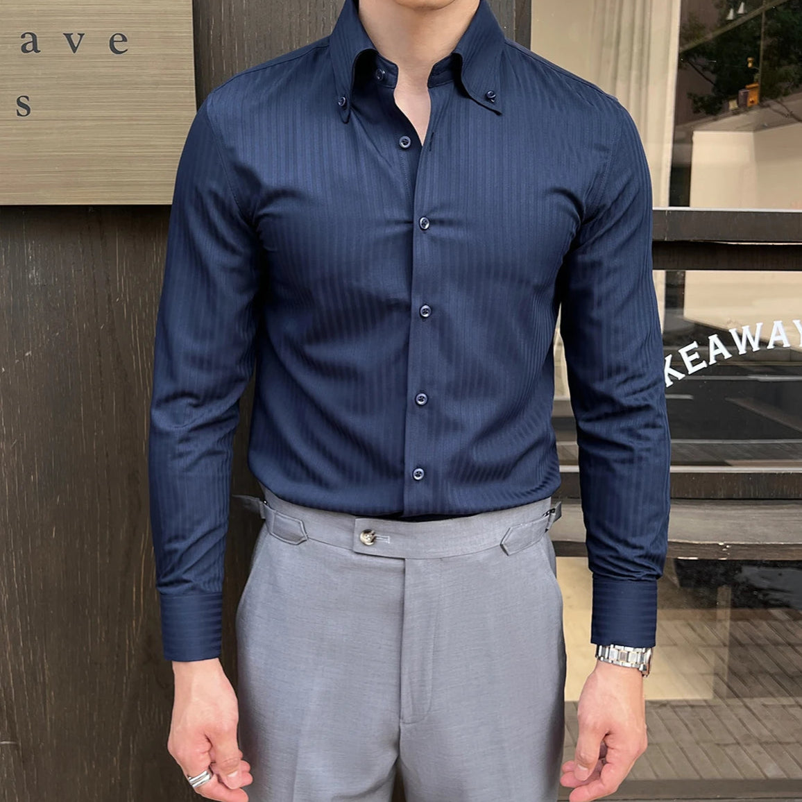 Chemise slim pour homme en bleu marine avec rayures foncées, col rabattu élégant et coupe ajustée, idéale pour un style chic et décontracté.