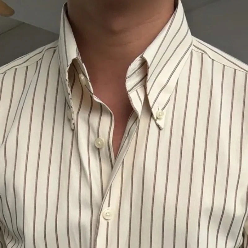 Zoom sur le col rabattu classique et le boutonnage simple de la chemise crème rayée marron. Mise en valeur des détails de finition du col et des boutons, accentuant la qualité et le design élégant de la chemise.