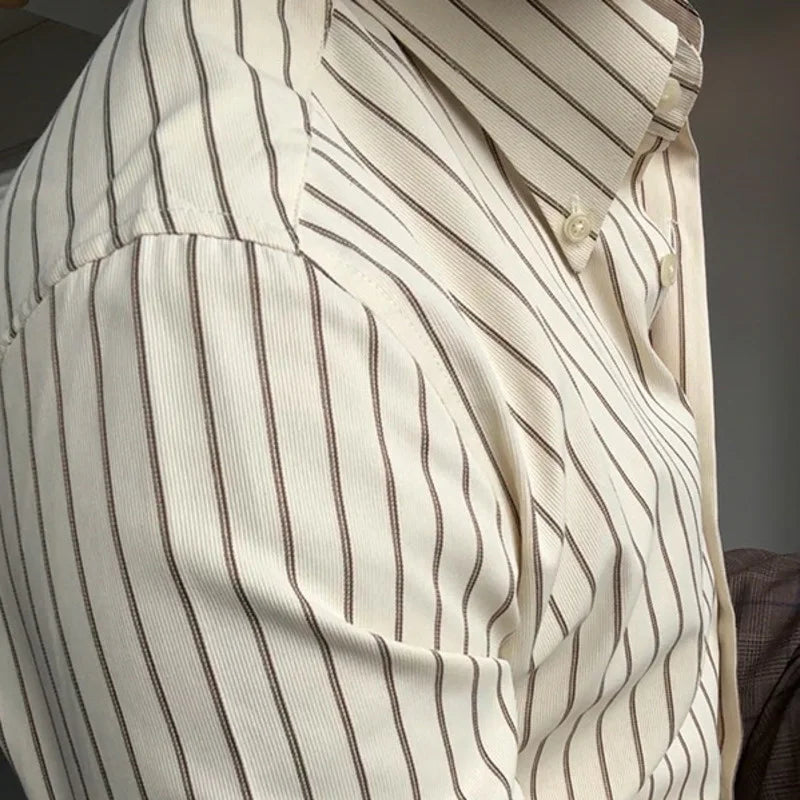 Vue de face détaillée mettant l’accent sur la texture du tissu de la chemise crème rayée marron. Le polyester de haute qualité présente un tissage soigné, avec des rayures fines mais distinctes, offrant une finition lisse et un confort optimal pour un look à la fois sophistiqué et décontracté.