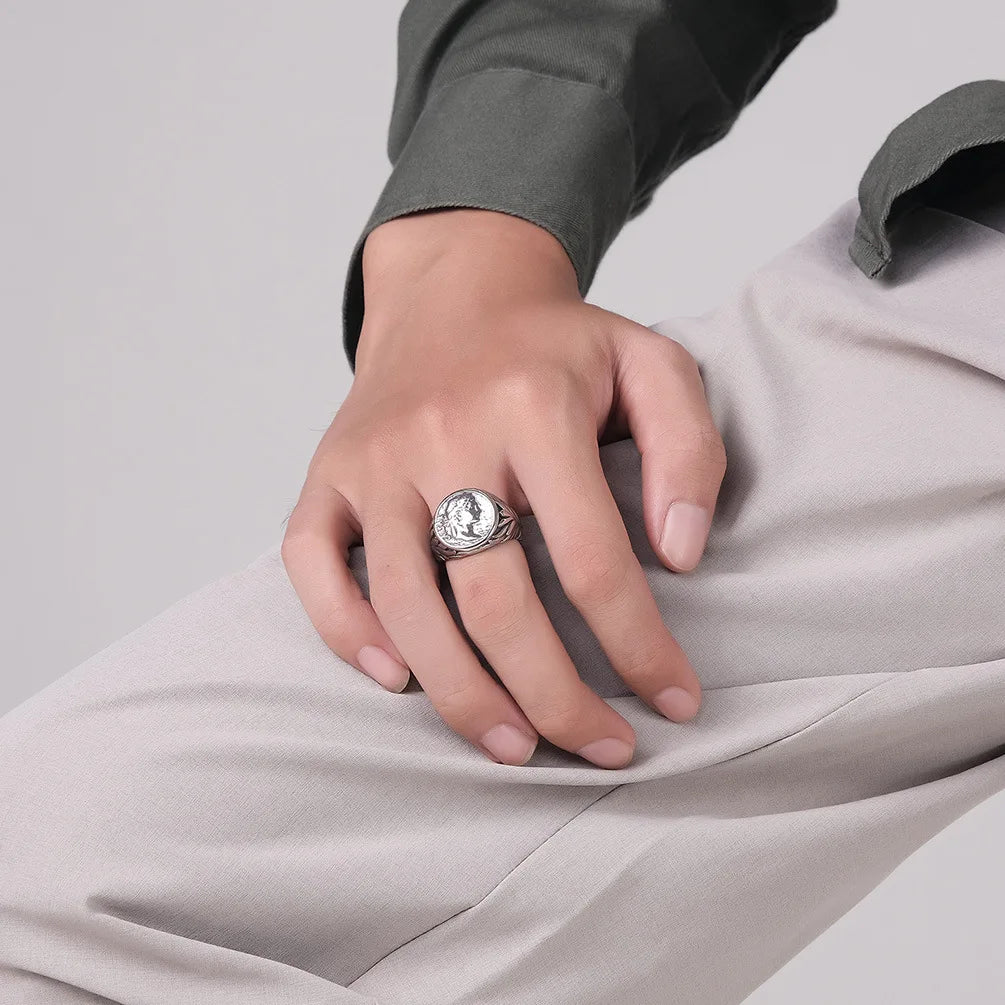 Homme portant la bague chevalière vintage, acier inoxydable doré, gravure détaillée style antique.