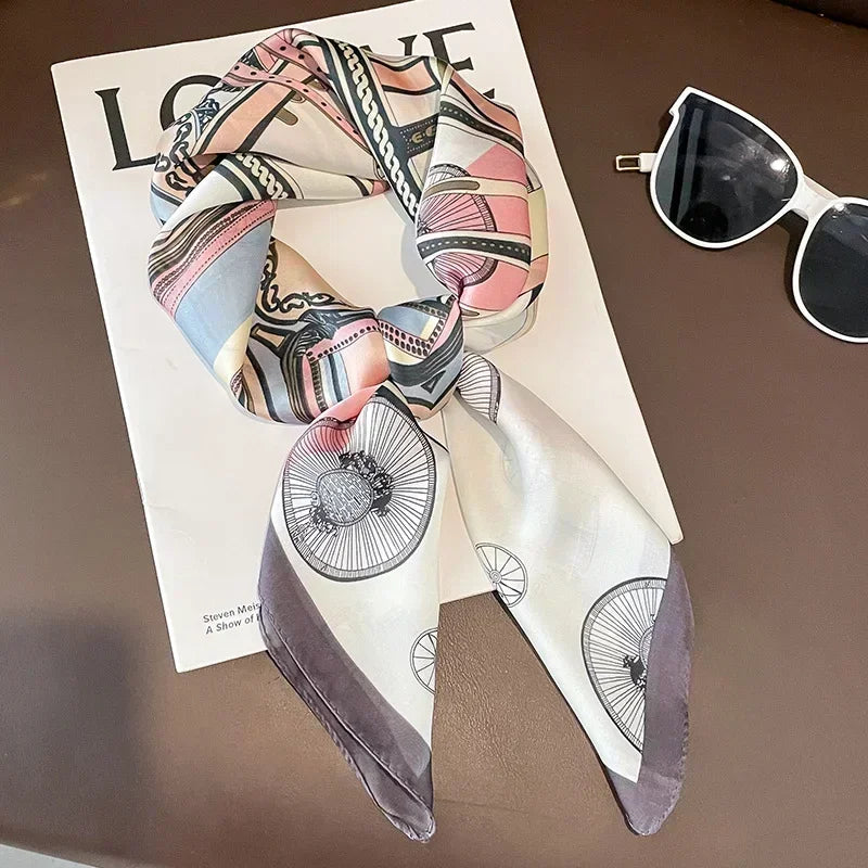 Foulard carré en satin aux tons rose, violet et bleu marine présenté à plat.