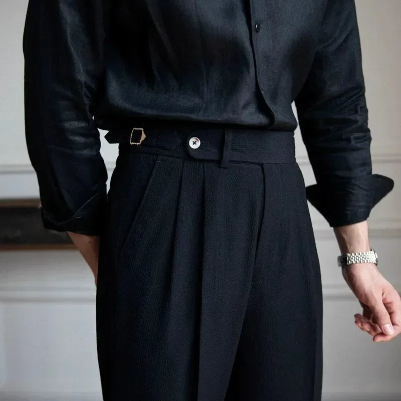 Détail de la taille du pantalon ASHBURY noir. Ceinture structurée avec bouton et ajusteurs latéraux avec pince pour un maintien sur mesure et confort optimal.