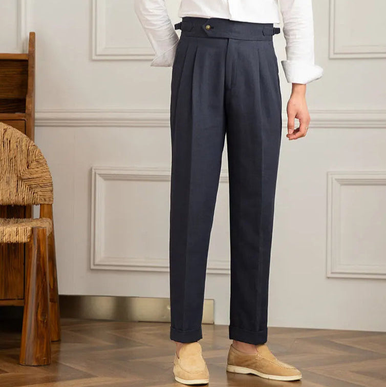 Homme portant le pantalon BEAUMONT bleu marine en lin, chemise blanche et mocassin en daim, élégance raffinée pour la mi-saison