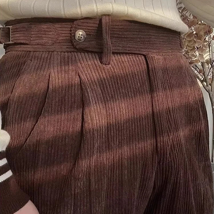 Le pantalon LOXLEY café en velours côtelé avec une coupe slim moderne. Détail sur la texture luxueuse du velours et la finition impeccable de la ceinture ajustable.