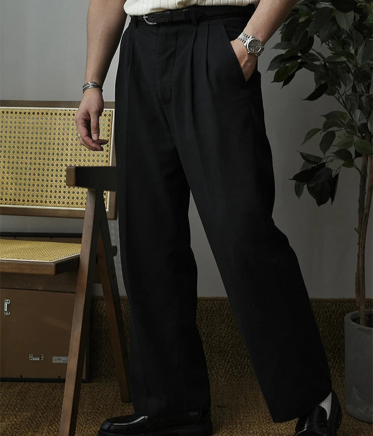 Focus sur la finition parfaite du pantalon SLOANE noir. Le tissu léger et respirant assure un confort optimal, tandis que les plis marqués et la coupe ample apportent une touche de raffinement moderne.