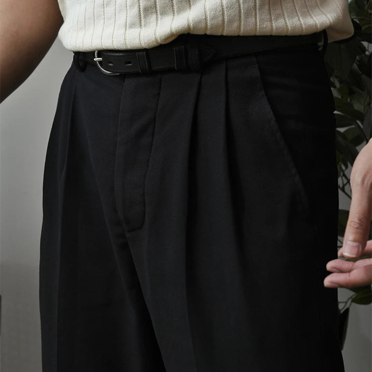 Zoom sur le pantalon SLOANE noir, soulignant ses plis marqués et sa coupe fluide. Un pantalon habillé au style moderne et décontracté, idéal pour diverses occasions.