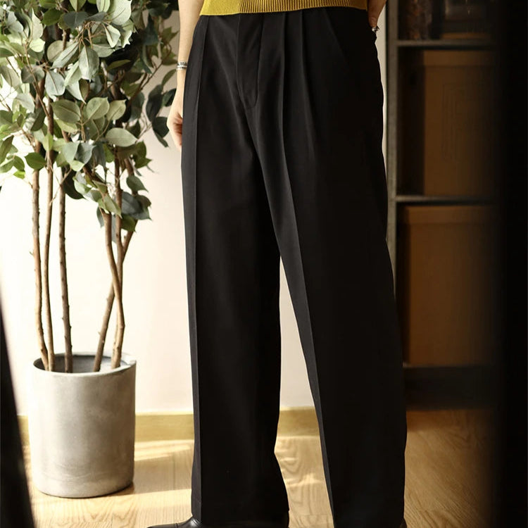Vue du pantalon SLOANE noir, avec sa coupe droite ample et ses plis marqués, pour une silhouette élégante et structurée. Le tissu respirant assure un confort de longue durée.