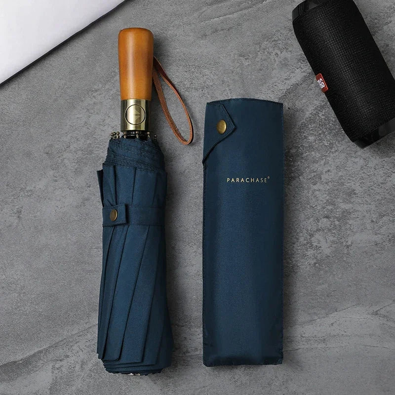 Zoom sur le parapluie bleu marine trois volets, avec manche en bois et tissu pongé doux, offrant une protection parfaite contre le vent et la pluie, rangement facile.