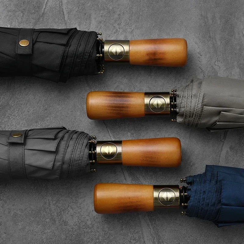 Zoom sur les parapluies automatiques à trois volets, de coloris noir, bleu marine et kaki, avec manches en bois, tissus pongé doux et squelette en fibre de verre.