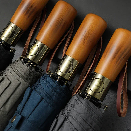 Détail des parapluies fermés, montrant la double couche coupe-vent, le design subtil, le manche en bois de qualité.