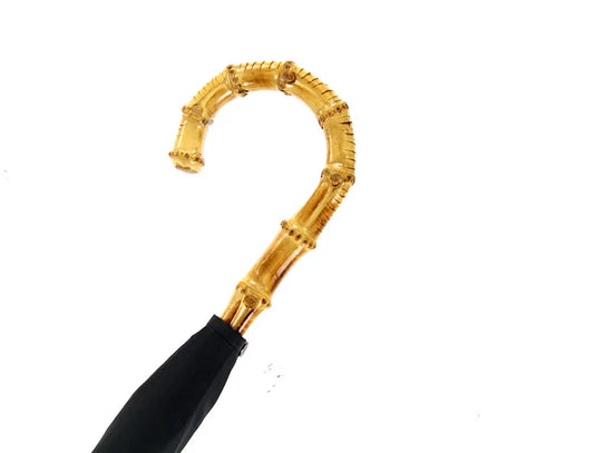 Gros plan sur le manche du parapluie en bambou naturel sculpté, finition naturelle et élégante