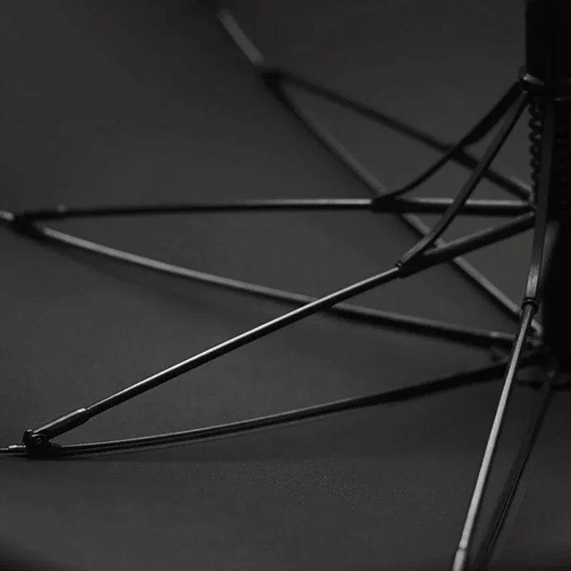 Gros plan sur l'intérieur du parapluie noir en bambou naturel. Coupe vent garantit
