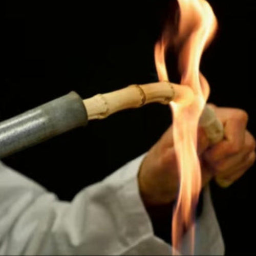 Zoom sur la fabrication : bambou en cours de préparation avec une flamme, savoir-faire ancestral, étape clé pour renforcer sa structure