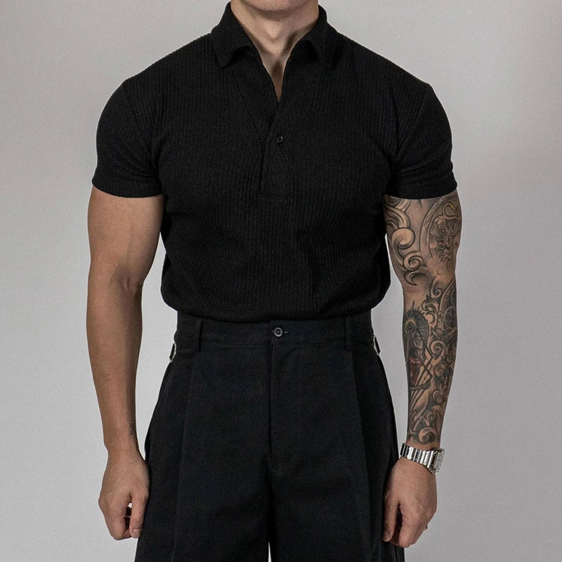 Polo côtelé en tricot noir porté avec un pantalon de costume noir, look casual vintage