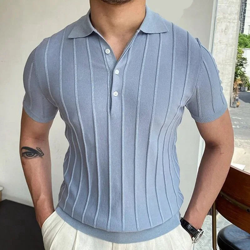Homme portant un polo rayé bleu clair à col V italien, dans un look Old Money chic et décontracté.