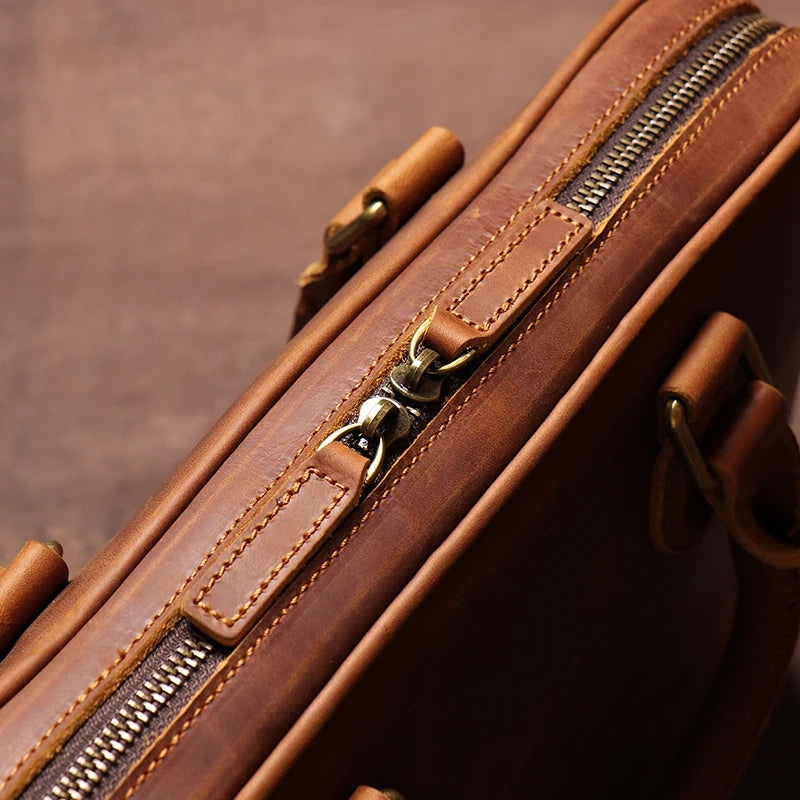 Zoom sur le cuir de vachette marron du sac porte-documents vintage et sur la fermeture de qualité, mettant en avant sa texture naturelle et sa qualité haut de gamme.