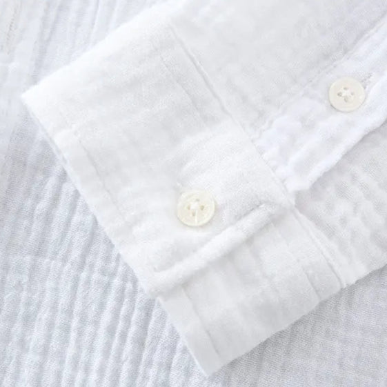 Détail des manches de la chemise décontractée blanche pour homme, en double gaze froissée. Tissu léger et respirant offrant une sensation agréable au toucher, idéal pour les journées chaudes ou fraîches.