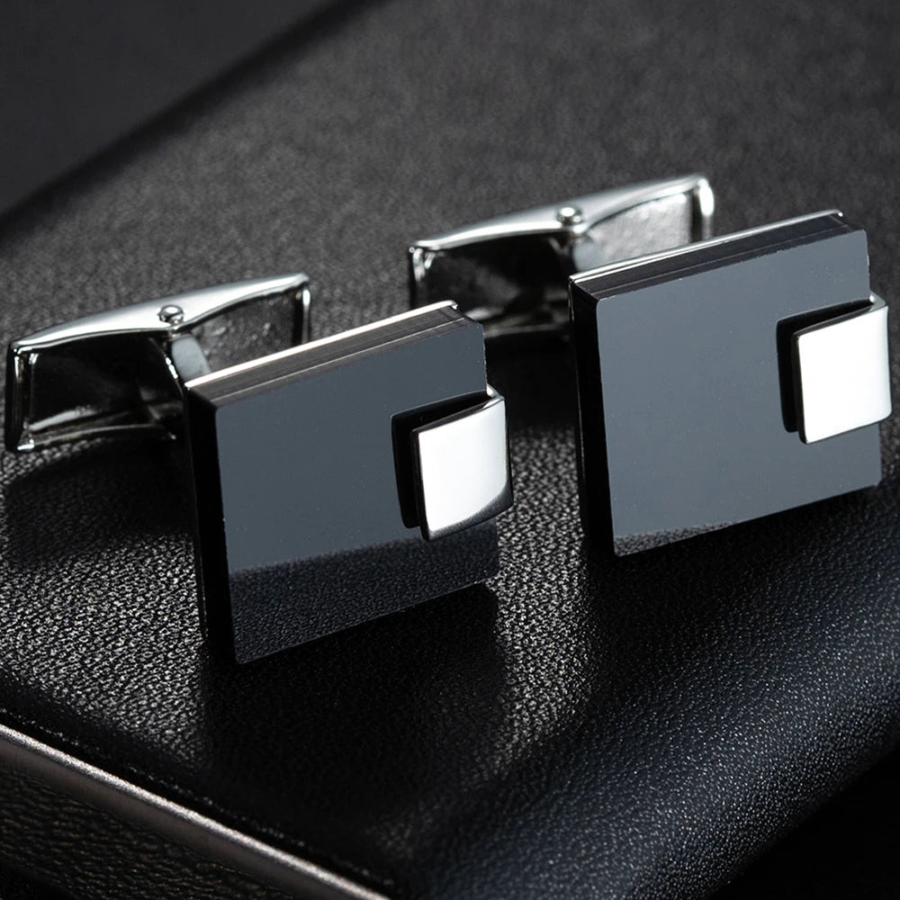 Accessoire raffiné : boutons de manchette noir mat et argent, finition brillante, détail chic pour un costume homme