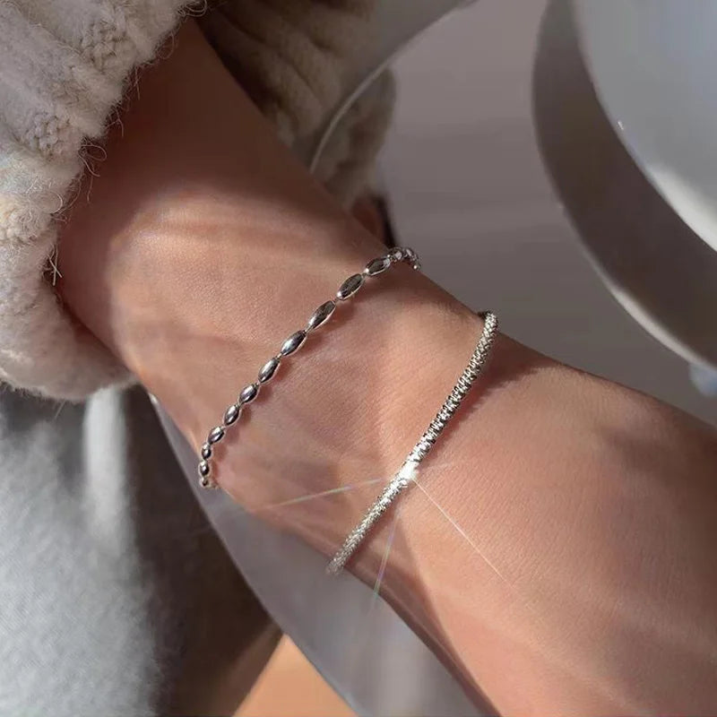 Bracelet double couche en argent 925 porté au poignet féminin – mise en valeur d’un style délicat et contemporain.