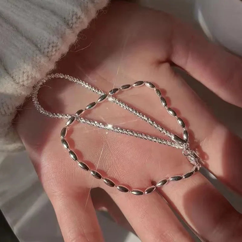 Bracelet double couche en argent 925 porté au poignet féminin – mise en valeur d’un style délicat et contemporain.