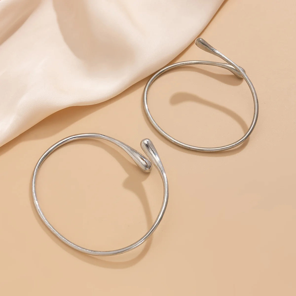 Version argentée du bracelet de bras goutte d’eau associée à une robe d’été élégante.