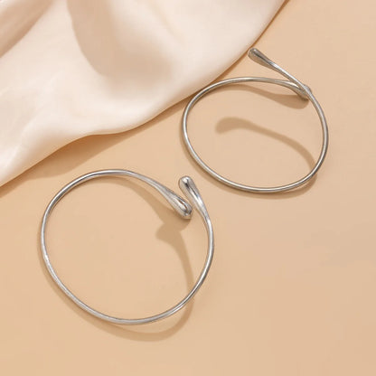 Version argentée du bracelet de bras goutte d’eau associée à une robe d’été élégante.