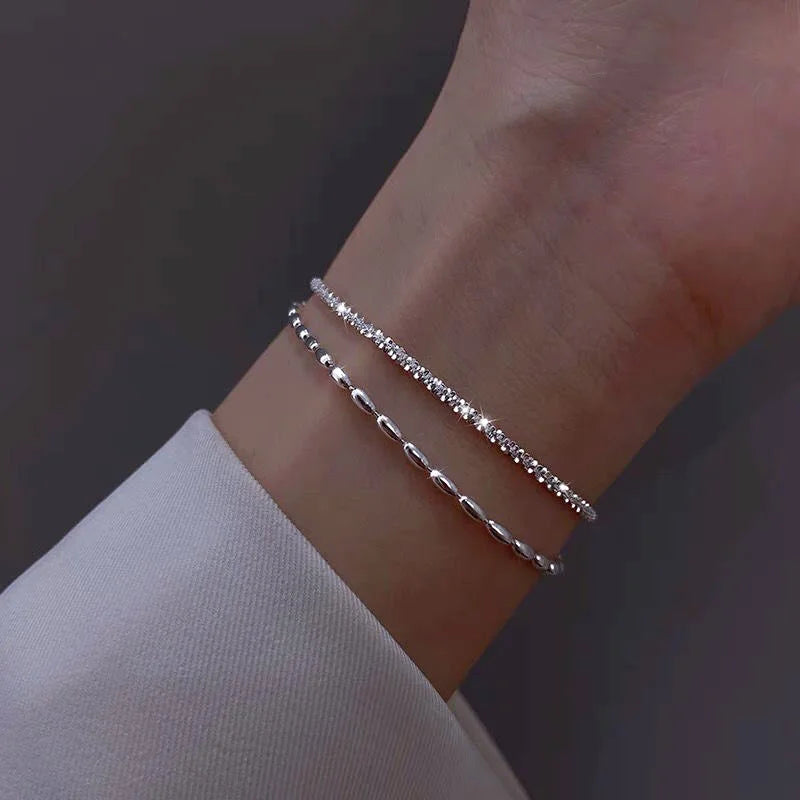 Bracelet double couche en argent 925 porté au poignet féminin – mise en valeur d’un style délicat et contemporain.