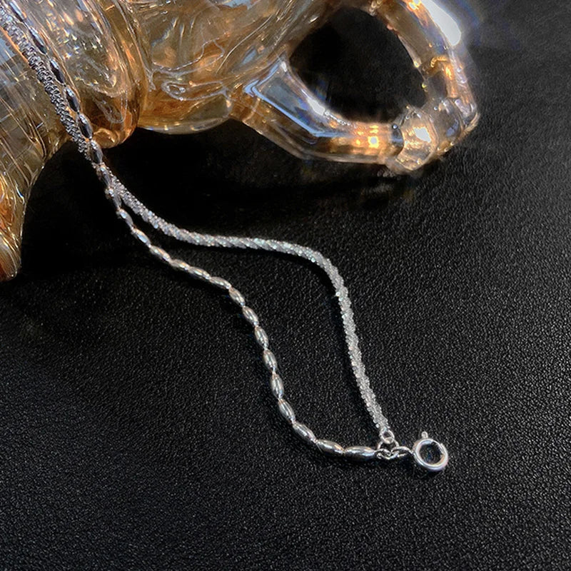 Vue rapprochée du bracelet montrant la finesse de la chaîne et la brillance des maillons en argent massif.