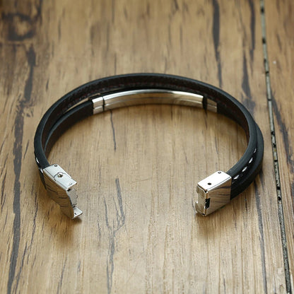 Zoom sur le fermoir du bracelet en cuir tressé noir avec plaque en acier inoxydable