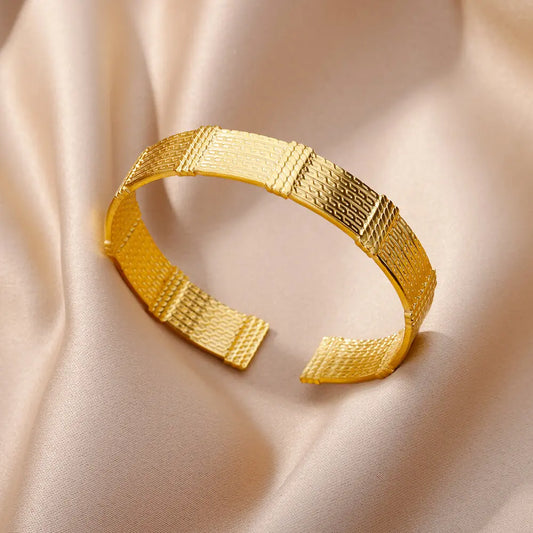 Bracelet doré pour femme, en acier inoxydable mettant en valeur sa finition brillante.