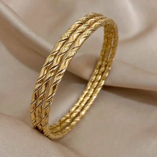 Bracelets torsadés dorés, parfait avec une tenue élégante.