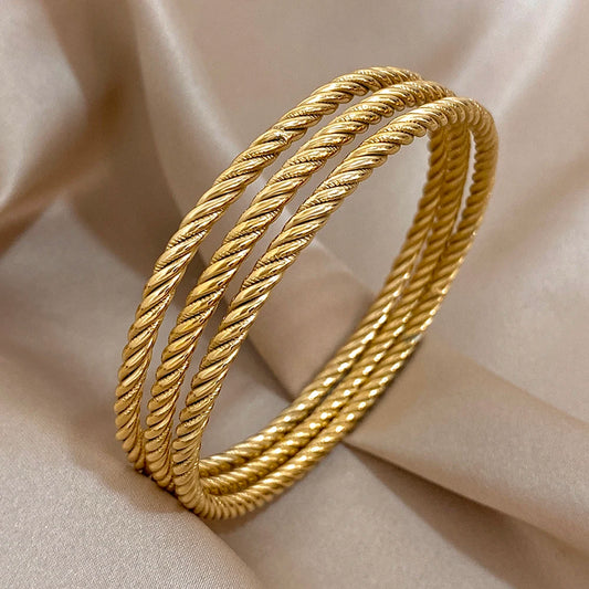 Bracelets torsadés dorés, parfait avec une tenue élégante.