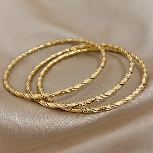 Bracelets torsadés dorés, parfait avec une tenue élégante.