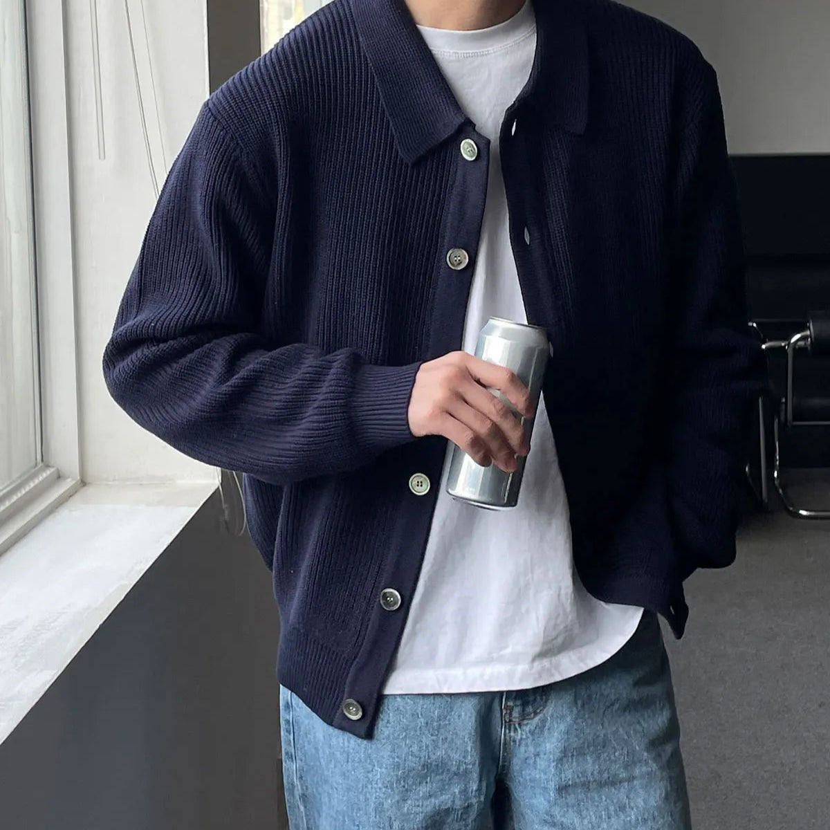 Le cardigan CONRAD bleu marine en laine, avec son col V et son tricot fluide, allie élégance et confort pour une silhouette parfaite.