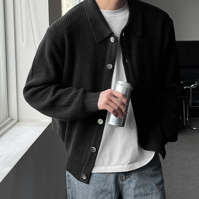 Cardigan CONRAD noir à col V, confectionné en tricot plat léger pour un style sobre et élégant. Une pièce incontournable du dressing masculin.