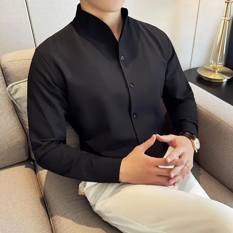 Homme portant une chemise col V noire avec un pantalon blanc, tenue professionnelle et élégante.