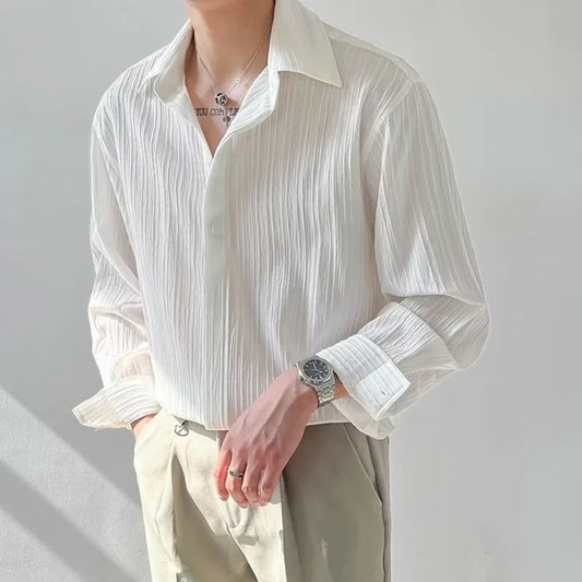 Chemise plissée blanche pour homme, coupe ample et fluide, boutonnage simple et col classique, élégante et décontractée.