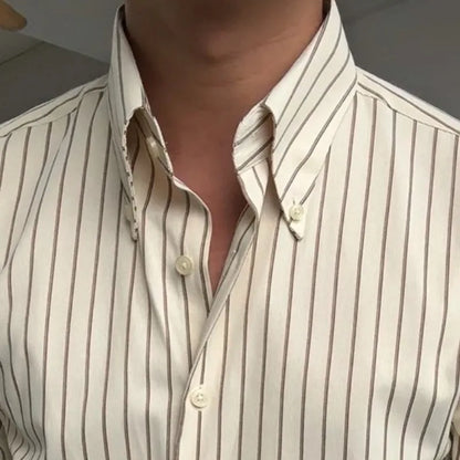 Zoom sur le col rabattu classique et le boutonnage simple de la chemise crème rayée marron. Mise en valeur des détails de finition du col et des boutons, accentuant la qualité et le design élégant de la chemise.
