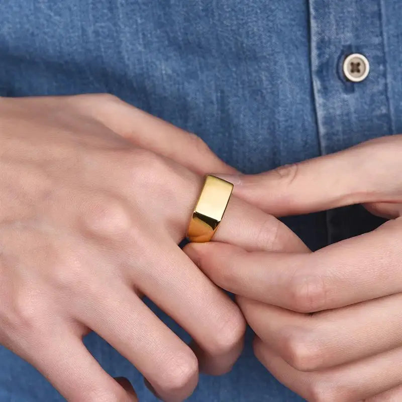 Homme portant la chevalière givrée en acier inoxydable, plaquée or, surface lisse, bijou minimaliste et élégant.