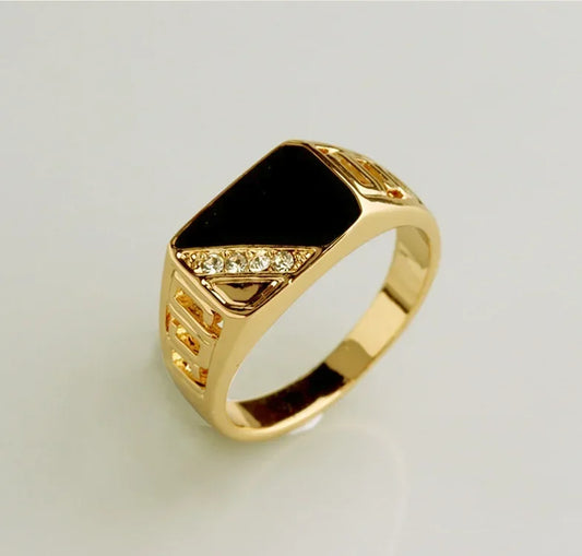 Bijou tendance, chevalière large en métal doré avec plaque noire brillante.
