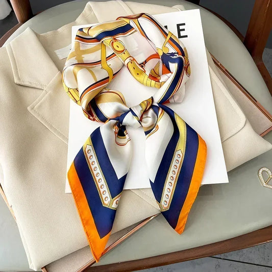 Gros plan sur les motifs vintage aux teintes orange, jaune, blanc et marine sur satin soyeux.